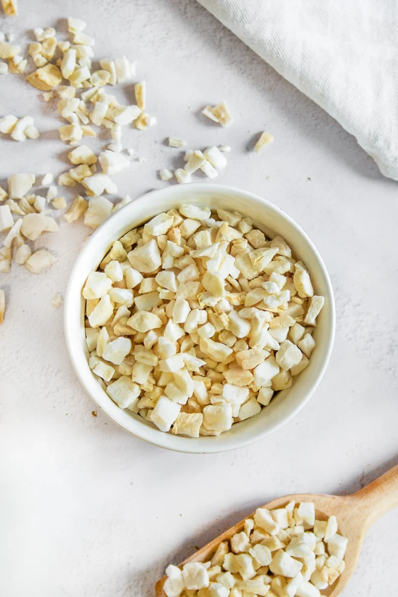Gefriergetrocknetes Apfelgranulat, knusprige Stücke in goldener Farbe, ideal für Müsli, Joghurt oder Desserts
